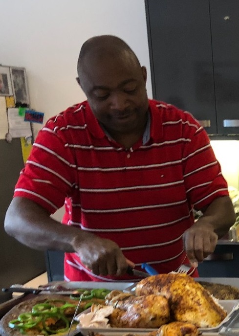 Uncle Paul carving roast chicken in the kitchen